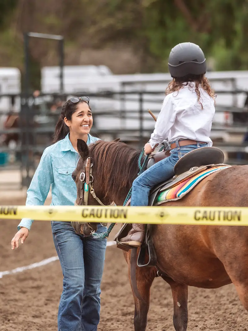 Volunteer leading a young rider